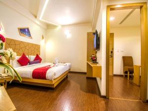 a hotel room with a bed and a television at Hotel Rockdale in Visakhapatnam