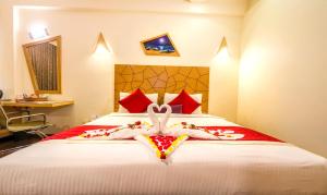 a hotel room with a bed with a towel animal on it at Hotel Rockdale in Visakhapatnam