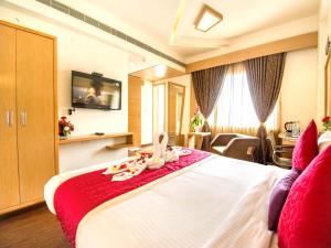 a hotel room with a bed with a red blanket at Hotel Rockdale in Visakhapatnam