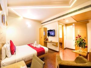 a hotel room with a bed and a tv at Hotel Rockdale in Visakhapatnam