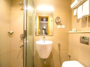 a bathroom with a shower and a sink and a toilet at Hotel Rockdale in Visakhapatnam