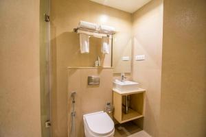 a bathroom with a toilet and a sink at Hotel Rockdale in Visakhapatnam