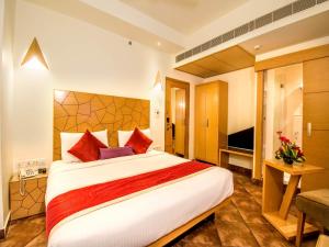 a hotel room with a large bed and a television at Hotel Rockdale in Visakhapatnam