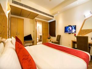 a hotel room with a bed and a television at Hotel Rockdale in Visakhapatnam