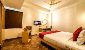 a hotel room with a bed and a tv at Hotel Rockdale in Visakhapatnam