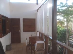 a dining room with a table and a large window at Guaco House in Jericoacoara