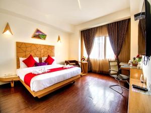 a hotel room with a large bed and a desk at Hotel Rockdale in Visakhapatnam