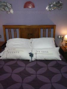 
a bed with two pillows on top of it at Hotel Casa de la Fuente in Alcorisa
