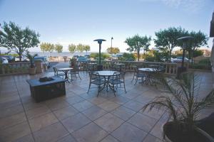 a patio area with tables, chairs and umbrellas at Bay Landing Hotel in Burlingame