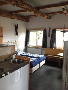 um pequeno quarto com uma cama e um lavatório em De Droomhut em Den Hoorn