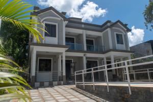 a large white house with a balcony at Fantasea Villa - Mont Choisy in Mont Choisy