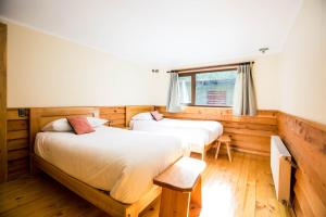 a bedroom with two beds and a window at Kalfu Patagonia in Cochrane