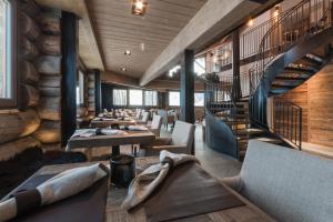 a restaurant with tables and chairs and a spiral staircase at Sunny Valley Mountain Lodge in Bormio