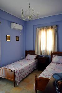 a bedroom with two beds and a window at Mezapos Villa Makrina in Mézapos