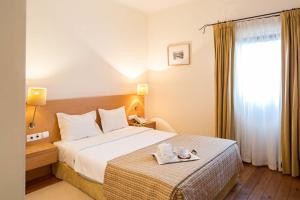 a hotel room with a bed with a tray on it at Hotel Rural de Charme Maria da Fonte in Póvoa de Lanhoso