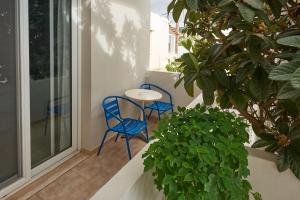 un patio con 2 sillas y una mesa en el balcón en Corali Studios en Plakiás