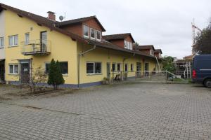 una casa amarilla con una entrada delante de ella en Stollis FeWo en Bensheim