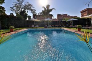 a large swimming pool with blue water in a yard at Hotel Oasis in Córdoba +41 photos