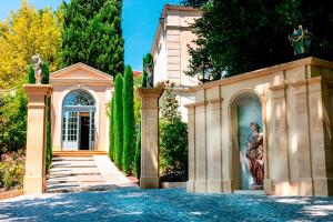 a house with a statue on the side of a driveway at Villa Gallici Hôtel & Spa in Aix-en-Provence