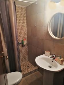a bathroom with a sink and a shower with a mirror at Mezapos Villa Makrina in Mézapos +17 photos