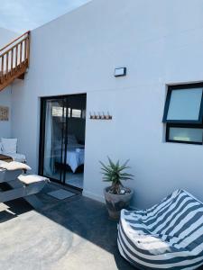 a room with a blue wall with a bed and a couch at Lower Point Surf Studio in Jeffreys Bay