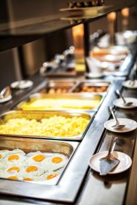 a buffet line with eggs and other food items at All Senses Nautica Blue Exclusive Resort & Spa - All Inclusive in Fánai