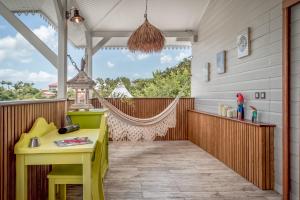 - une terrasse couverte avec une table jaune et un hamac dans l'établissement La Maison de Clementine, à Fort-de-France