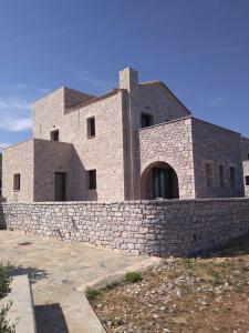 a large brick building with a stone wall at Mezapos Villa Makrina in Mézapos