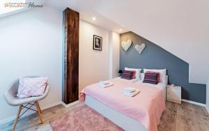 a small bedroom with a bed and a chair at Wonder Home - Apartamenty z balkonami Leśny Dom II - w cichej i zielonej części Karpacza in Karpacz +141 photos