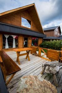 a wooden deck with a picnic table and benches at Kalfu Patagonia in Cochrane