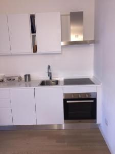 a white kitchen with a sink and a stove at Appartamento Ligeia in Bolzano