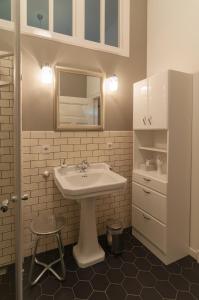 a white bathroom with a sink and a stool at Studio Apartment Berlin in Berlin