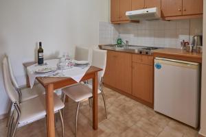 a kitchen with a table and chairs and a sink at Corali Studios in Plakias