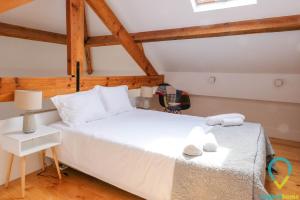 a large white bed in a room with wooden ceilings at Loft Almada in Porto