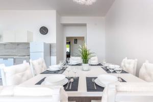 una sala da pranzo bianca con tavolo e sedie bianchi di Villa Veronique a Dramalj
