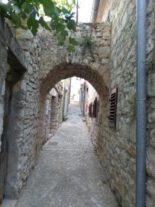 ベティナにあるKuća Getのアーチ道の古石造りの建物内の路地