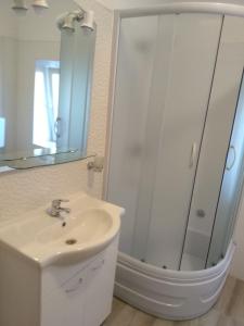 a white bathroom with a sink and a mirror at Kuća Get in Betina