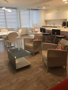 Il comprend un salon avec des chaises et des tables ainsi qu'une cuisine. dans l'établissement résidence tingitana, à Saint-Jean-de-Luz