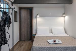 a bedroom with a bed with a tray of food on it at DownTown Hotel in Nafplio