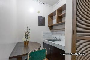 a kitchen with a wooden table and a sink at Victoria Mansions in Manila