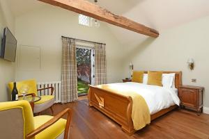 a bedroom with a bed and a table and chairs at The Mill, Long Melford in Long Melford