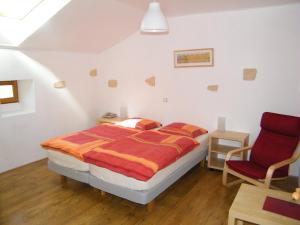 een slaapkamer met een bed en een rode stoel bij Maison Neuve Grandval in Grandval