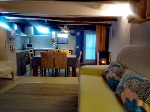 a living room with a couch and a kitchen at Casa Tuerta in Alcalá de Moncayo