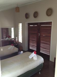 Musungwa Safari Lodge في Shanjungu: غرفة نوم بسريرين ونوافذ عليها مصاريع