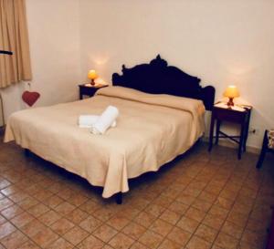 a bedroom with a large bed with two tables and two lamps at AGRITURISMO NUOVA FATTORIA in Borgo Sabotino
