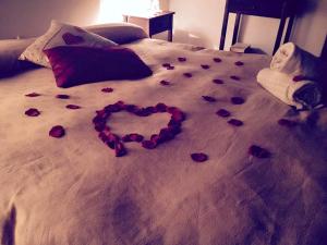 a heart made out of roses on a bed at AGRITURISMO NUOVA FATTORIA in Borgo Sabotino