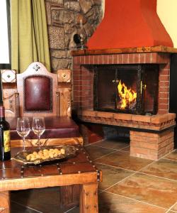 a living room with a fireplace and a table with wine glasses at Metohi in Marioláta