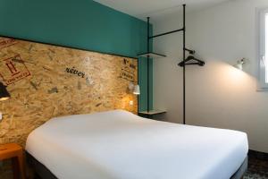 A bed or beds in a room at The Originals Access, Hôtel Clermont-Ferrand Nord