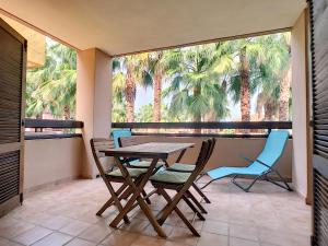 a table and chairs on a balcony with palm trees at Arona 2 - 0909 in Mar de Cristal