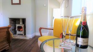 Sala de estar con mesa de cristal y botella de vino en The Mill, Long Melford en Long Melford